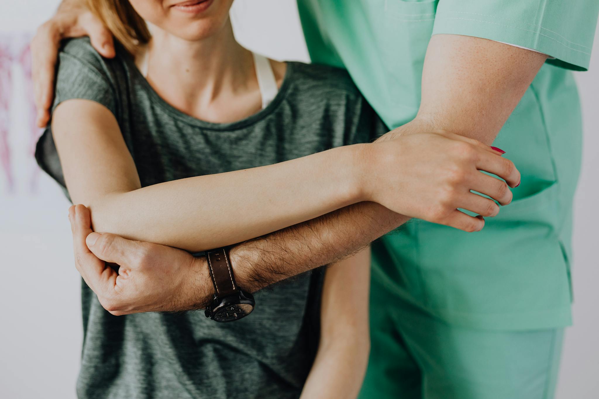 Professional therapist aids in arm rehabilitation during a session.